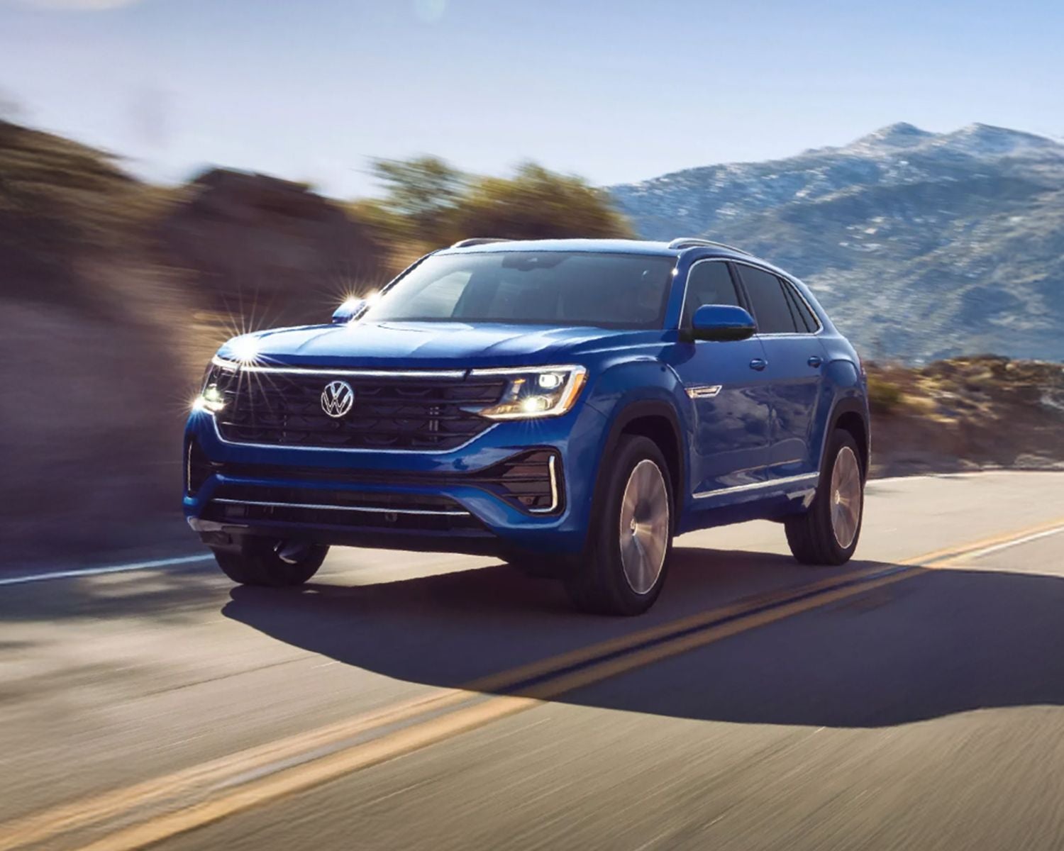 Blue SUV driving on a mountain road.